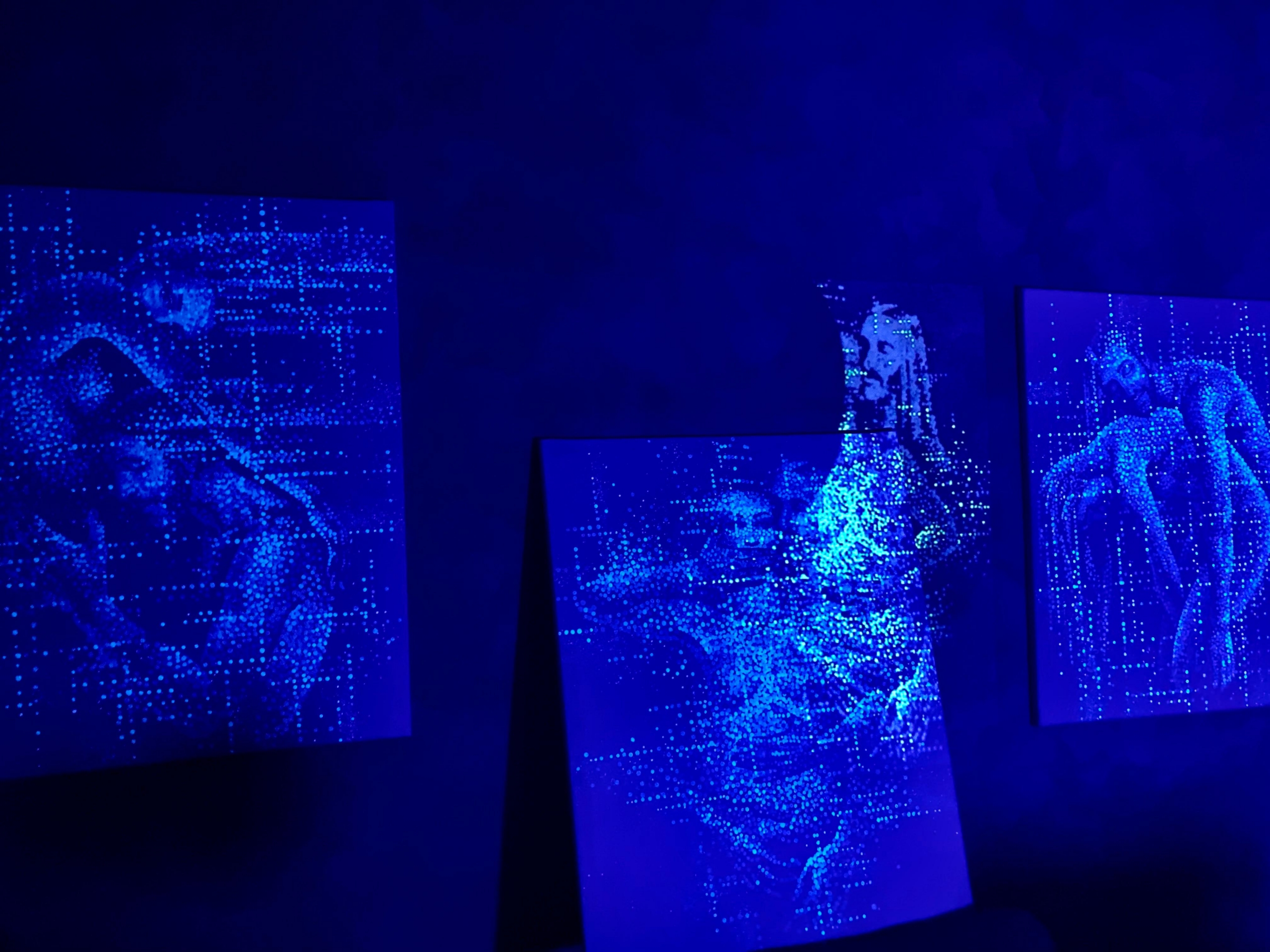 This triptych is made of fluo white on white, the white canvas show the artpiece only under UV lights. In this photo the central piece of the triptych is moved to the floor to show the beamer effect.